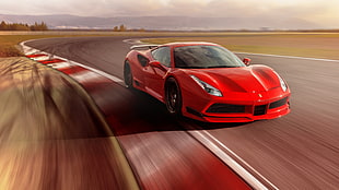 red Ferrari sports car on gray road