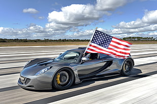grey sports car and USA flag during daytime