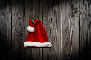 red Santa Hat on gray wooden wall HD wallpaper
