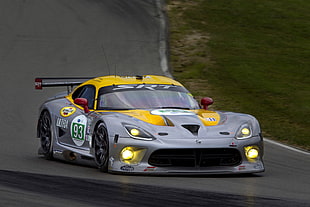 photograph of gray and yellow racing car