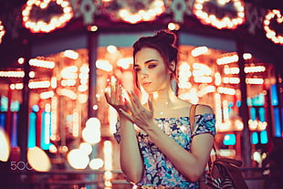 woman in blue and white dress off shoulder blouse standing in front of carousel