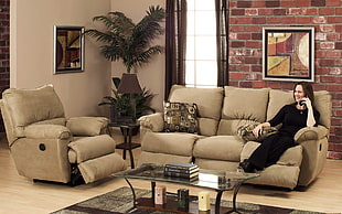 woman wearing black dress sitting on brown recliner couch