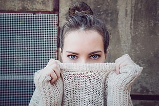 woman covering mouth with brown sweater