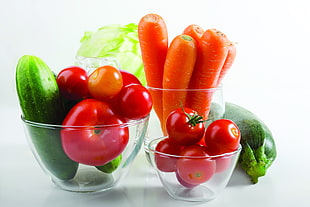 person showing fruits in clear glass bowls