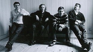four men sitting on chairs