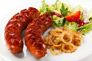 two cooked sausage with vegetables
