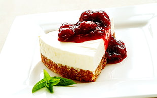 food photography of sliced flavored cake with red jam toppings served on white ceramic plate