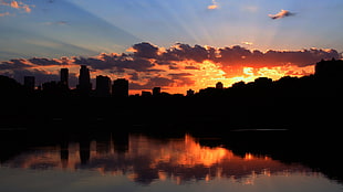 silhouette photo of Citysearch, skyline, sunlight, clouds, water