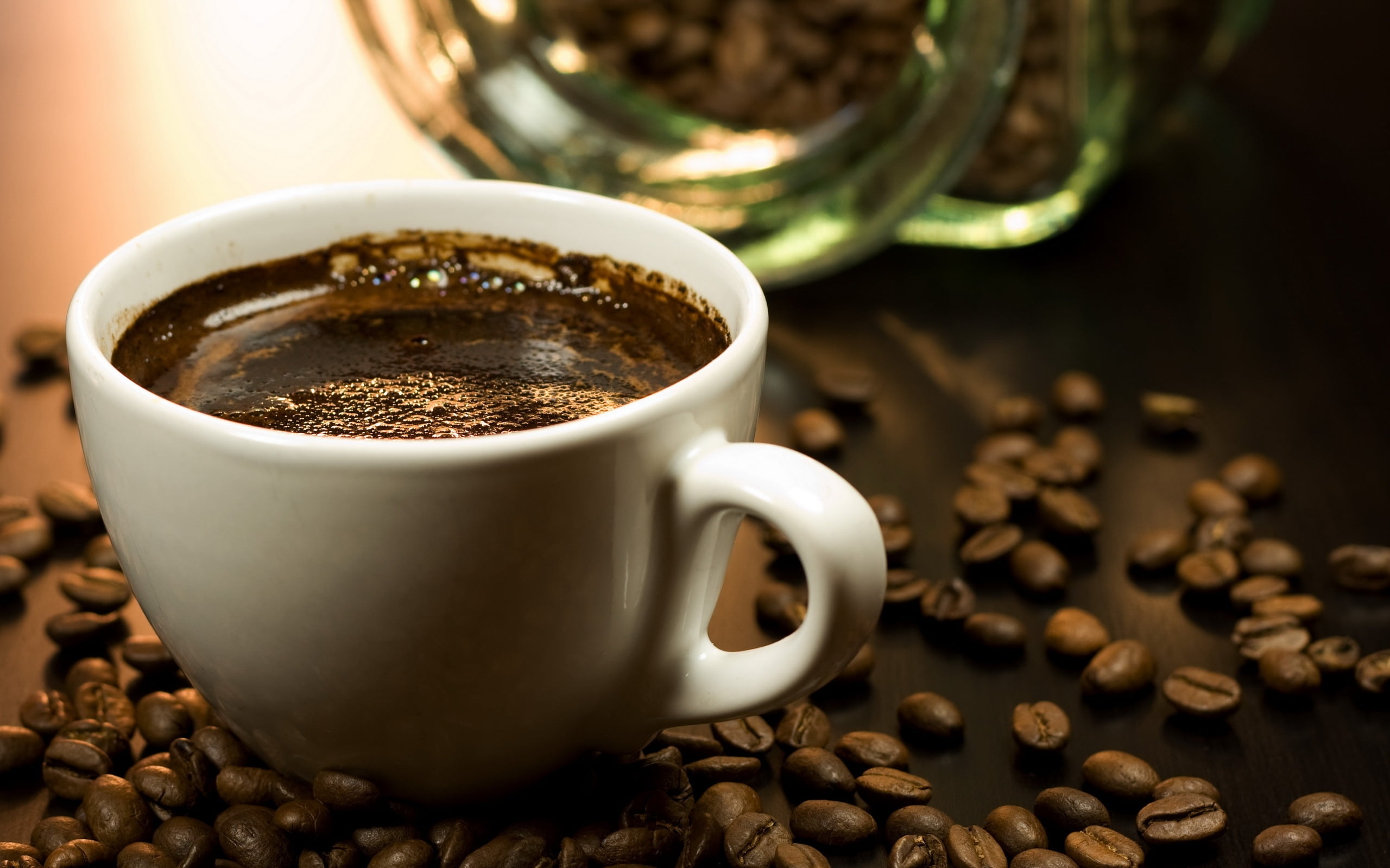 photo of white ceramic teacup with coffee beans