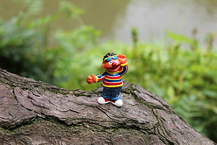 closeup photo of cartoon character figurine on brown tree during daytime