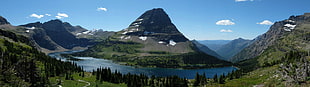 green mountain beside body of water