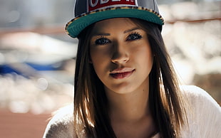 woman wearing green Obey fitted cap and white tops