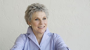 gray haired woman wearing blue notched lapel top