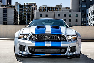 white and blue striped Ford Mustang parked on gray concrete road during daytime