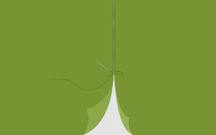 needle with thread on green textile