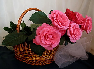 pink artificial flower on brown woven basket