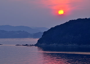 photography of green mountain during orange sunset HD wallpaper