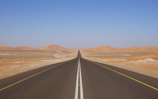 brown concrete road near desert