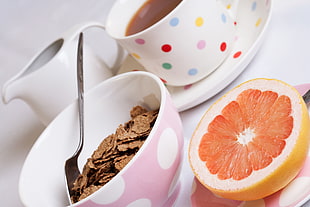 sliced lemon beside cereals in bowl with spoon on table