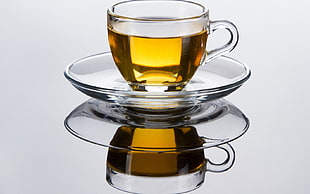 photography of clear glass cup on saucer