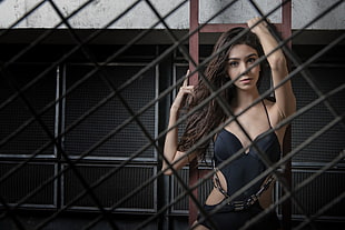 woman wearing black monokini behind black metal bars