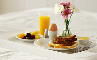 four toast bread loaves on white ceramic plate with egg on white ceramic cup