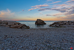 grey stone near shoreline during daytime