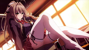 female anime character in black zip-up jacket and red and white plaid mini skirt sitting on brown wooden desk inside room