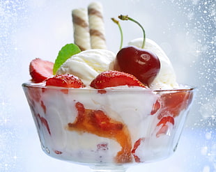 closeup photo of strawberry and wafer stick toppings ice cream served on clear glass cup