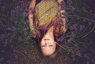 girl in yellow blouse lying on a purple flower field