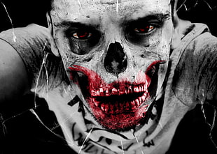 selective color photo of man with red bloody mouth and skeleton head close-up photo