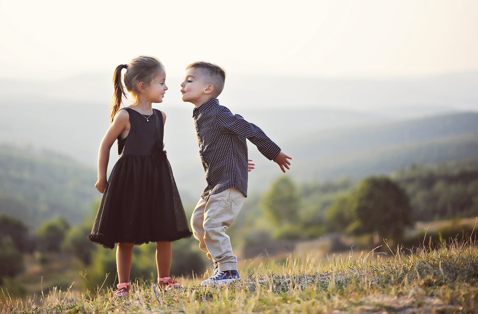boy and girl wearing black formal wear on hill photo
