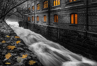 black and brown concrete building, dark, water, selective coloring, long exposure