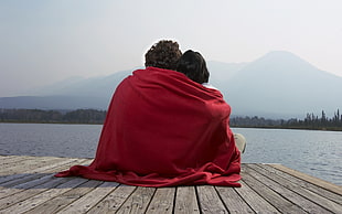 landscape photography of two person sitting on boat dock