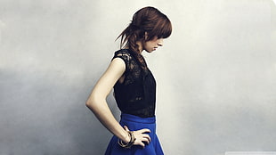 woman wearing black illusion-neckline sleeveless top and blue skirt