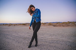 woman wearing blue denim button-up jacket and black leggings standing
