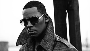grayscale shallow focus photography of man in plaid coat and sunglasses