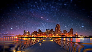 panoramic photography of bridge heading to lighted high-rise buildings during nighttime