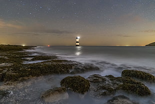 white and black lighthouse during night time, penmon, anglesey