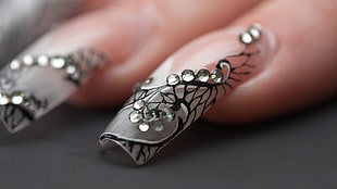 person with gray and black nail arts in close up photo