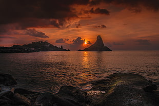 body of water under cloudy sky during sunset