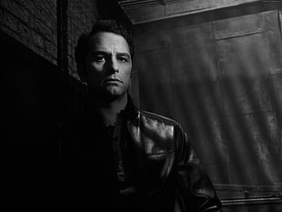 grayscale photo of man in leather jacket