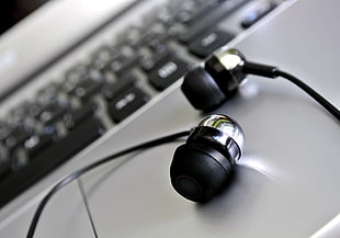 shallow focus photography of black earbuds
