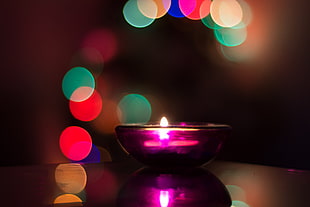 bokeh selective focus photography of purple candle holder