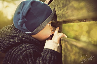 selective focus photography of toddler wearing blue hat and gray jacket, adrian