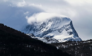 mountain cover by snow under the cloudy sky during daytime