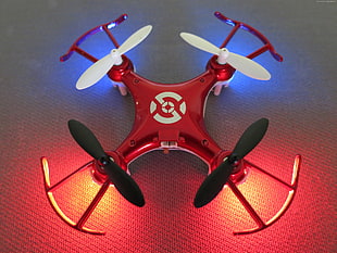 red, white, and black quadcopter drone