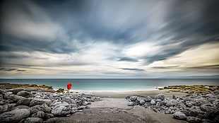 landscape photography of seashore under nimbus clouds background during daytime HD wallpaper