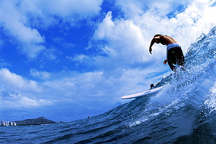 man riding surfboard in the middle of the sea waves