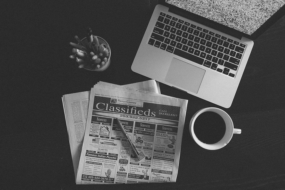 Classifieds news paper article beside coffee mug and MacBook Pro HD wallpaper